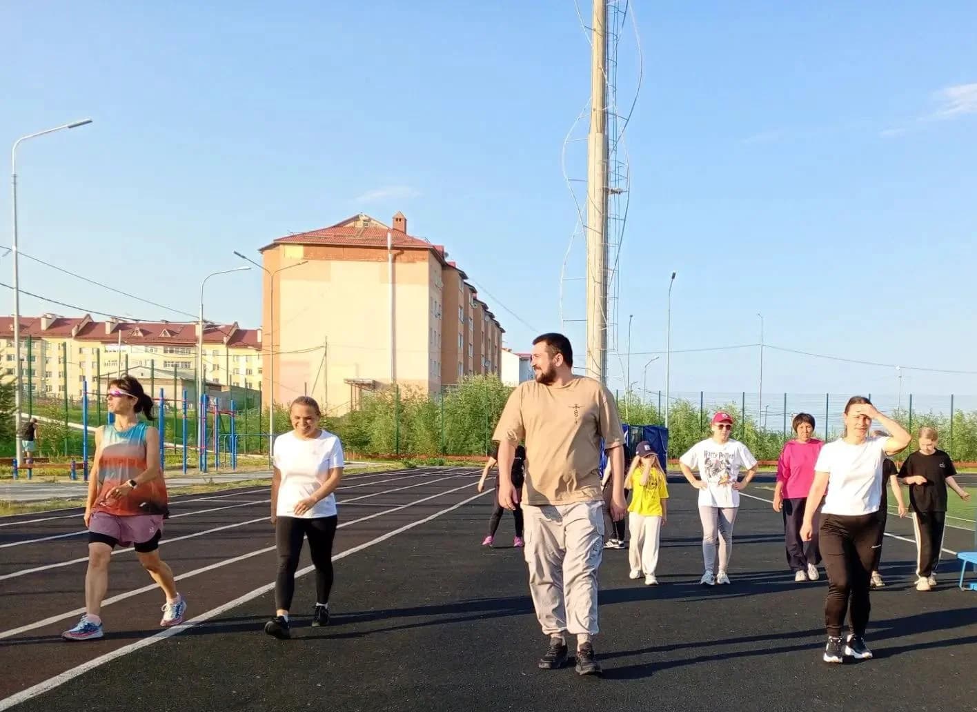 спортсмены с тренером на стадионе